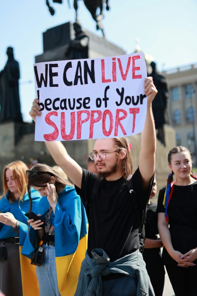Queer event with banner of 'We can live because of your support'